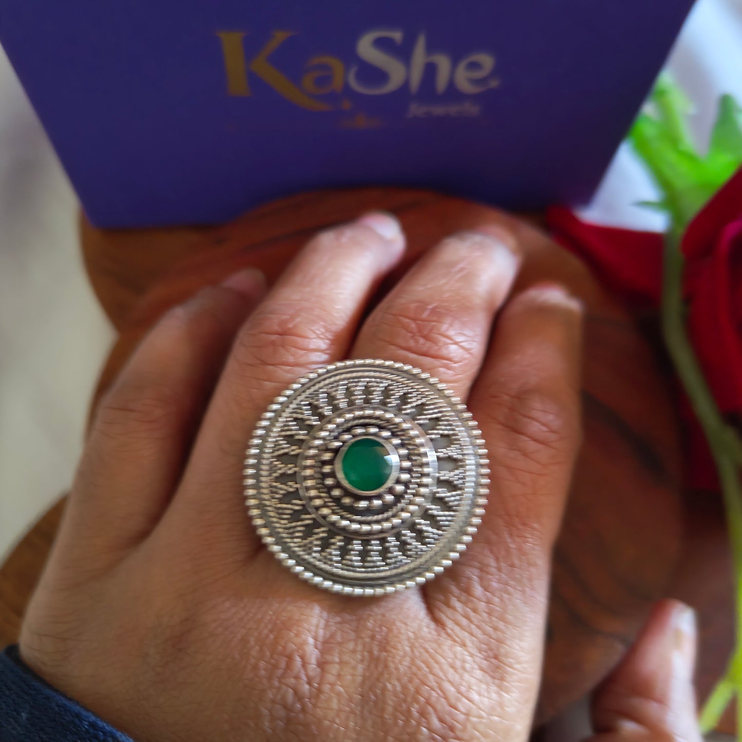 Circular Ring With Embossed Rava Design And Green Stone