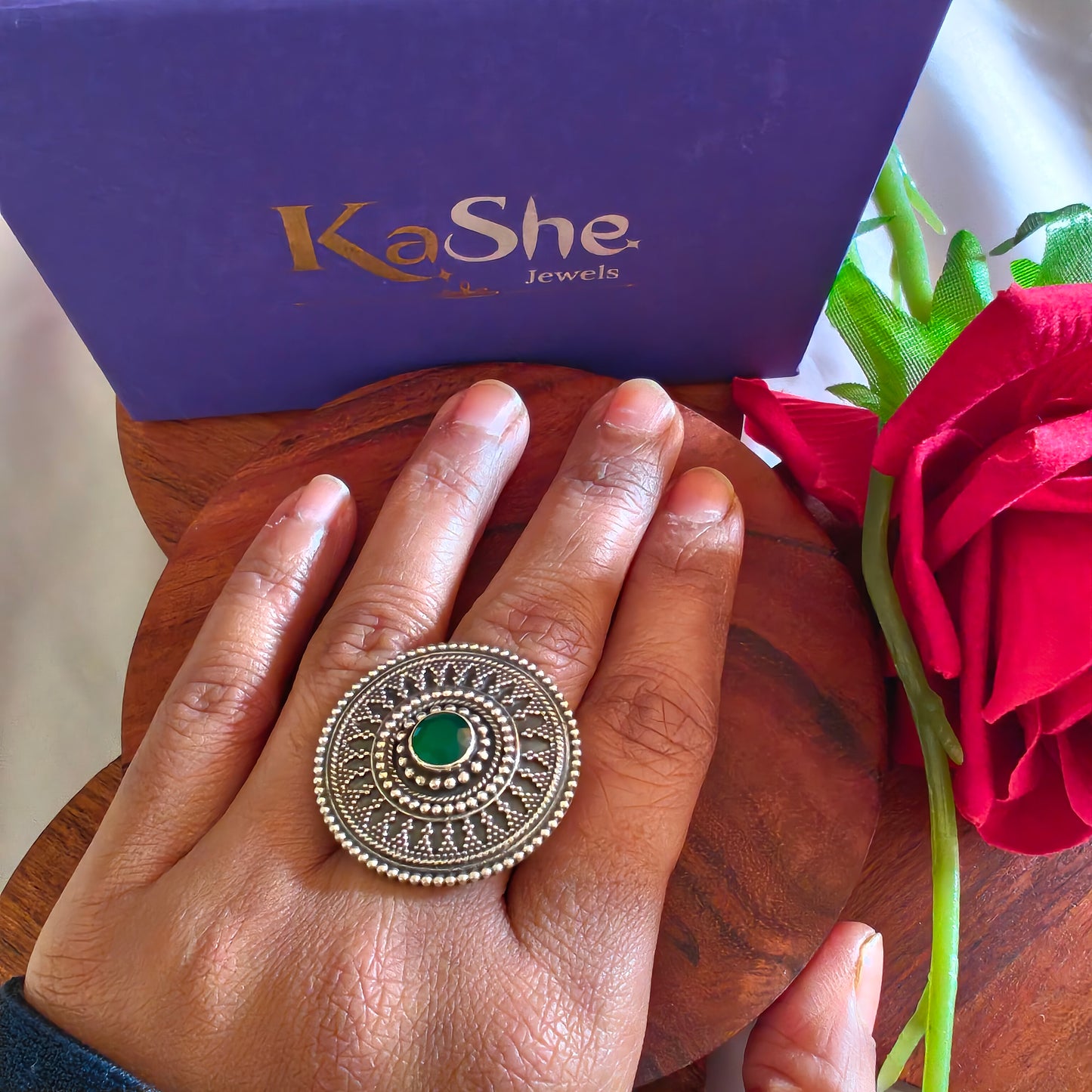 Circular Ring With Embossed Rava Design And Green Stone