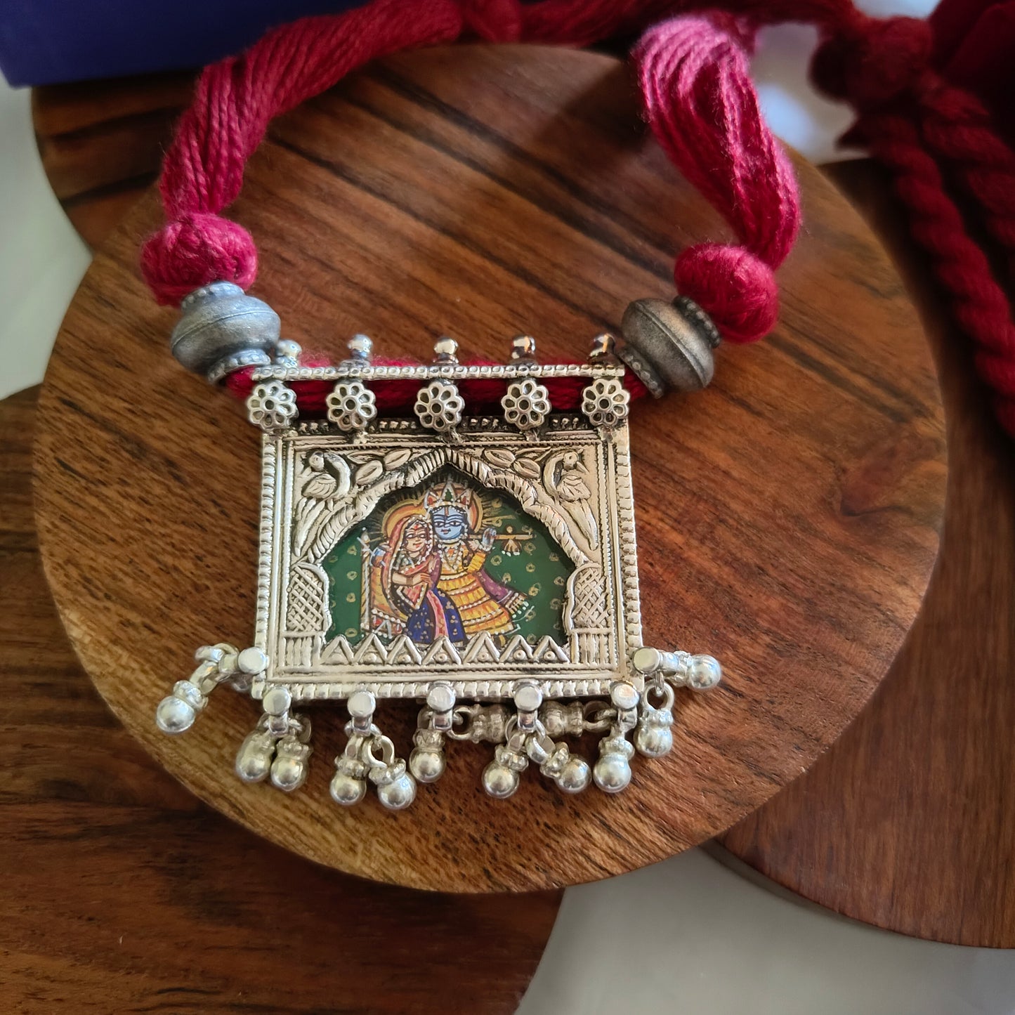 Radha Krishna Hand Painted Jharoka Pendant with Silver Ball Danglers and Maroon Thread Necklace Green Bg